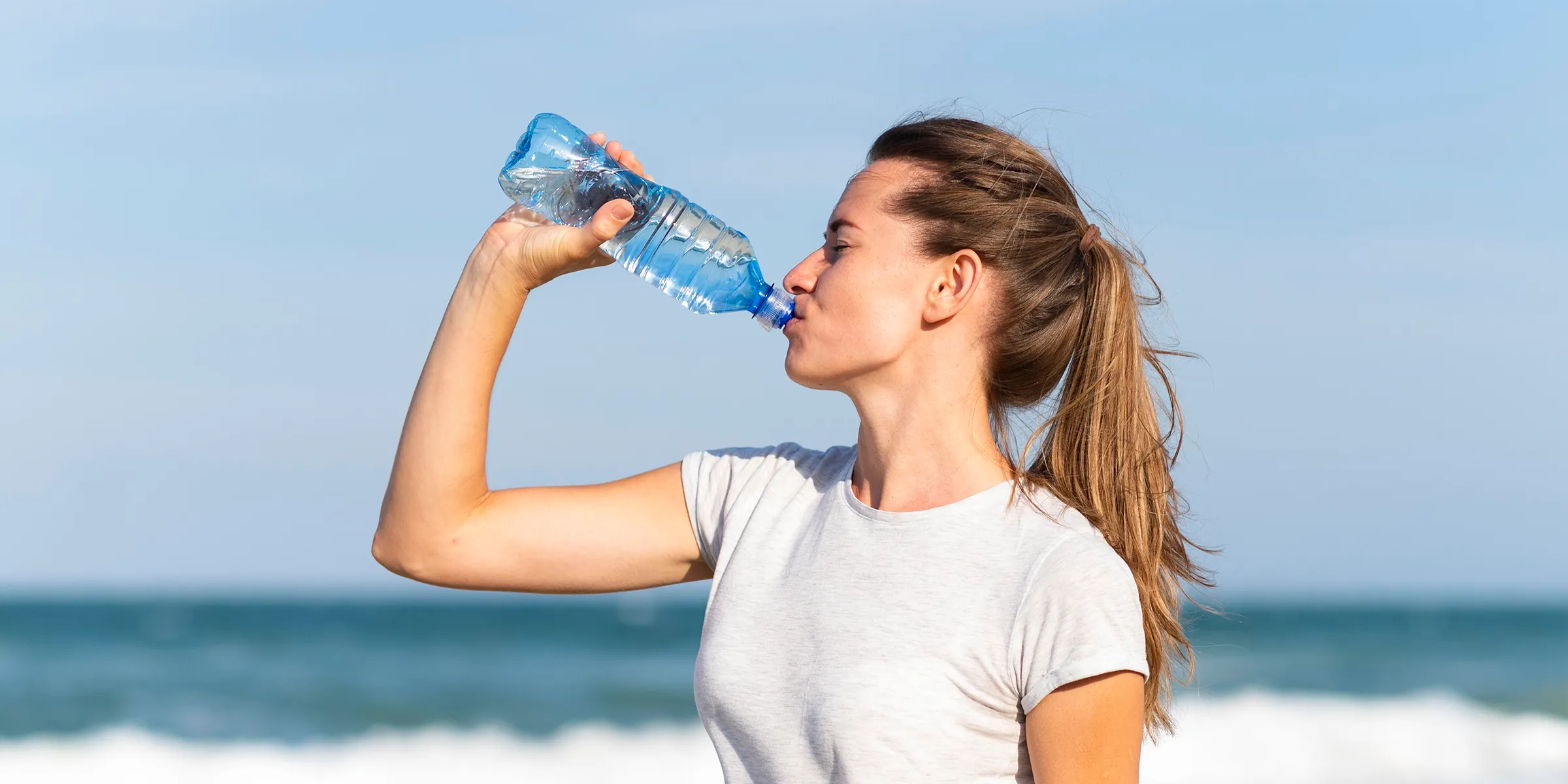 The importance of hydration for health, showing water being drunk at the beach